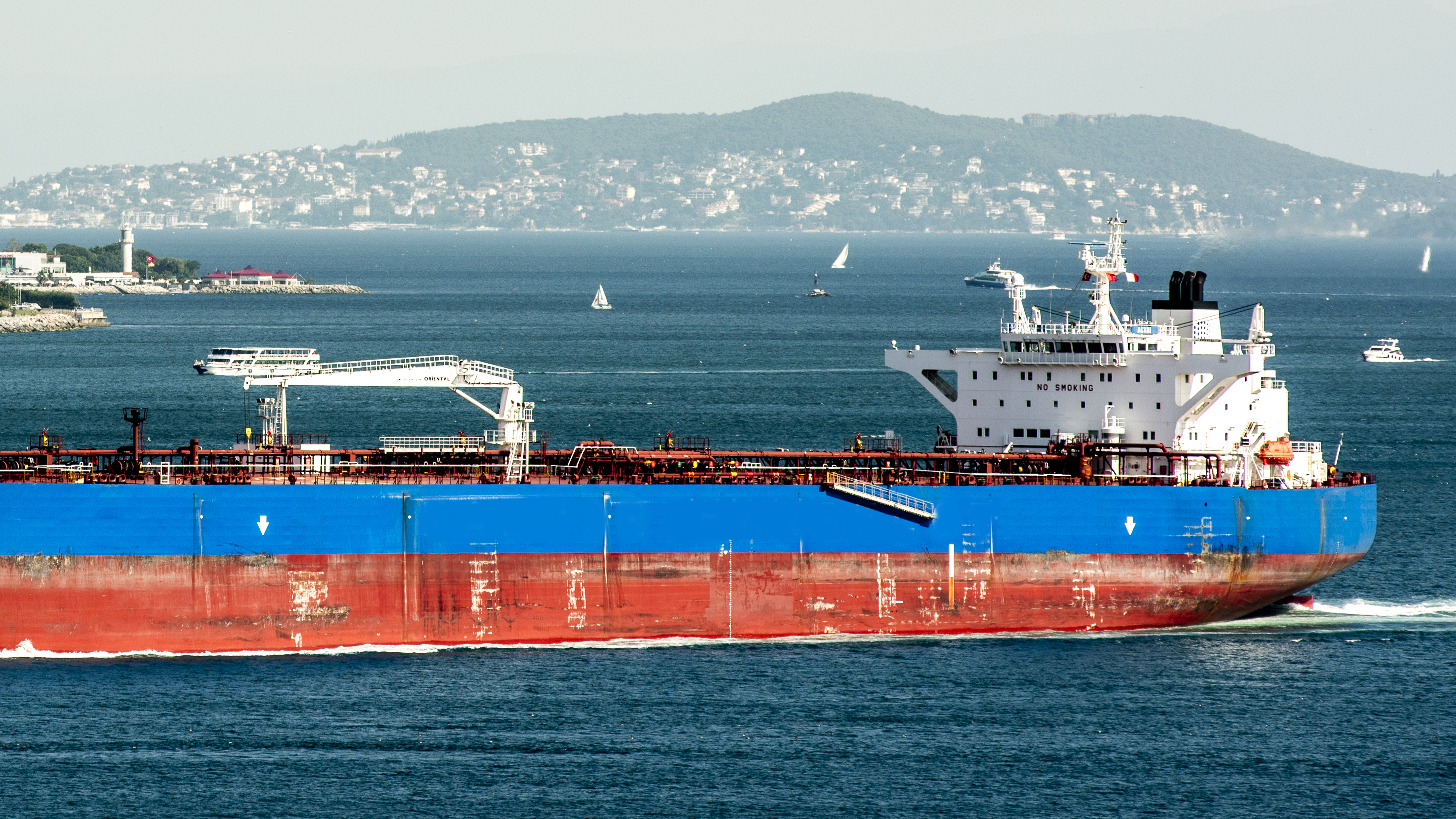 Buque petrolero azul y rojo en el mar cerca de la costa